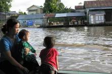 Eine Mutter mit zwei Kindern auf einem Boot.