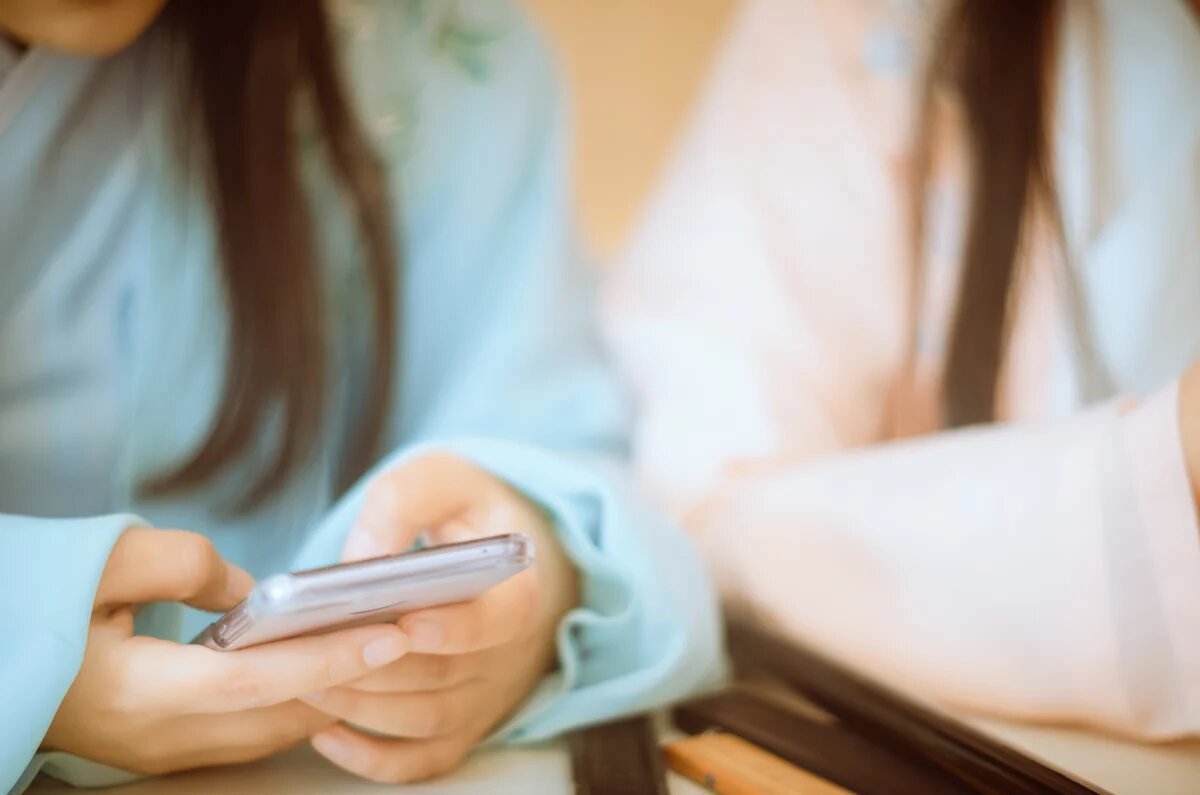 Die Social-Media-Flaschenpost Die Social-Media-Flaschenpost: Hände im Bildvordergrund tippen in ein Smartphone